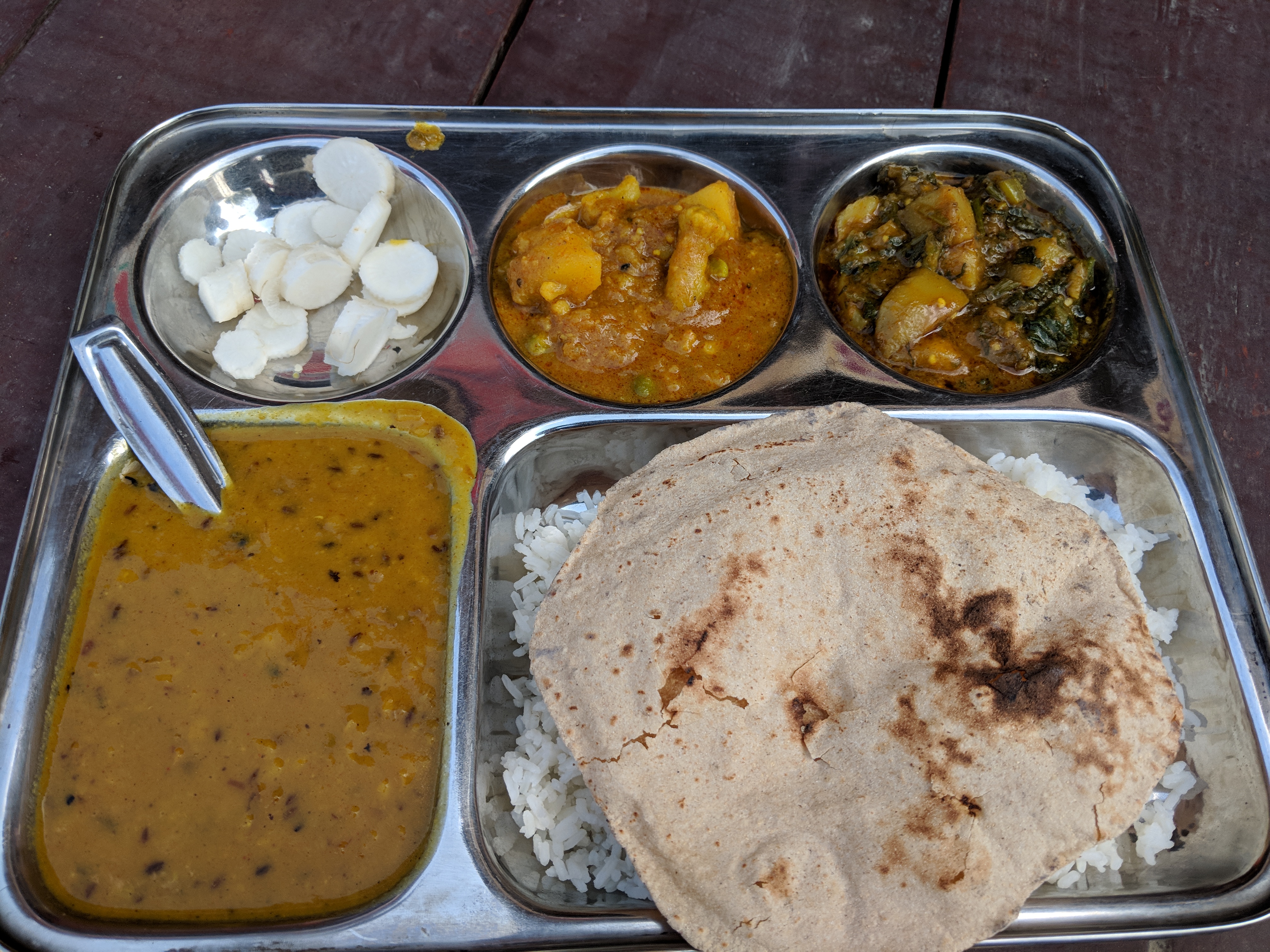 Two vegetable curries - One of Cauliflower with Peas and another with potatoes and spinach. Accompanying it is sumptuous dhal / pulses, salad and chapatis with Rice