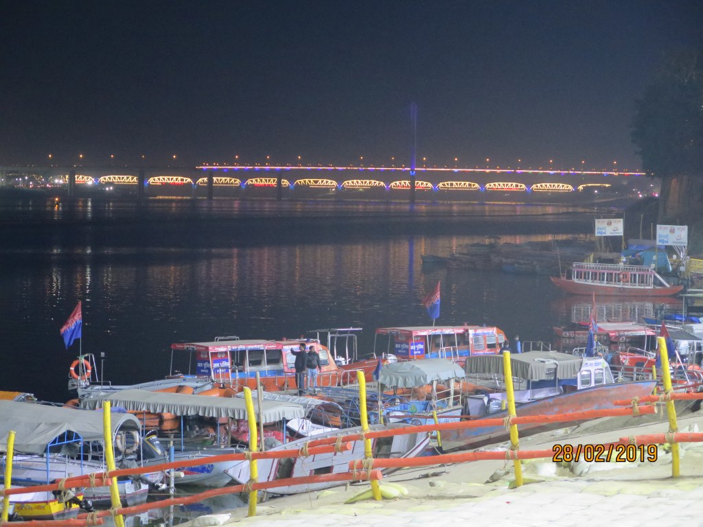 The well lit bridge viewed from the banks of the Ganges at Prayagraj