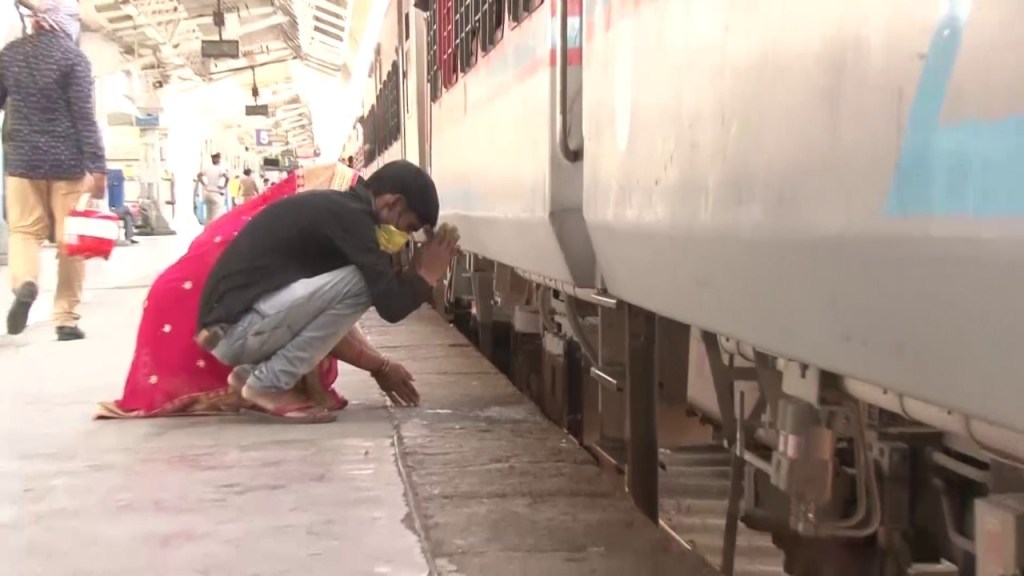 A couple praying before boarding a train back to their hometowns