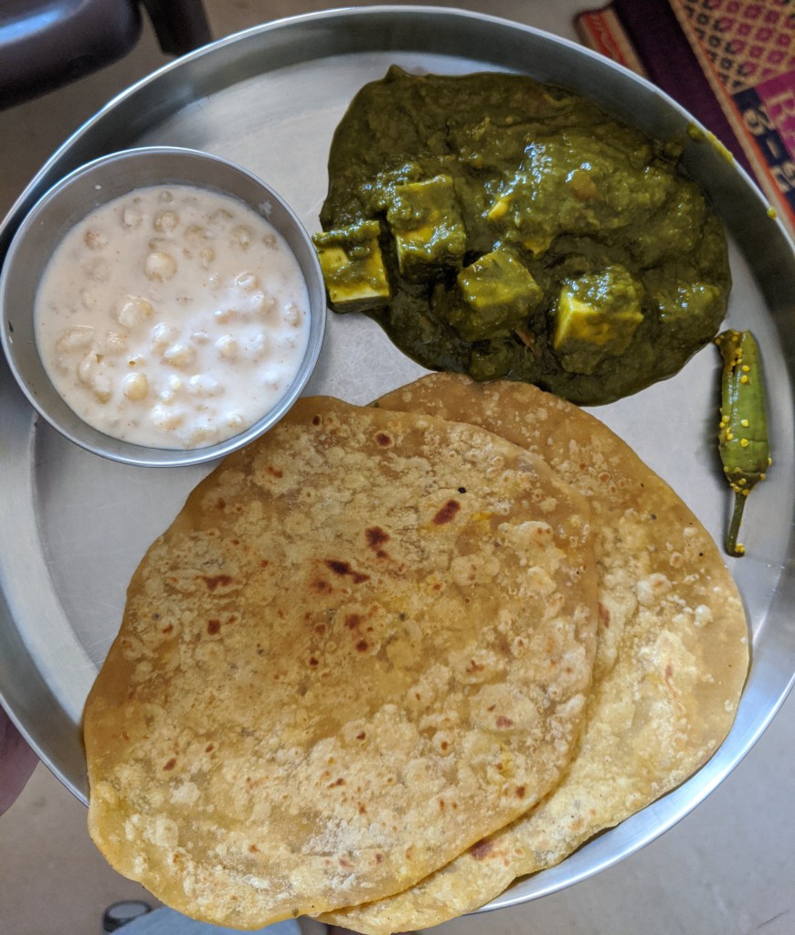 Palak paneer with two chapatis, boondi raita and a chilli pickle